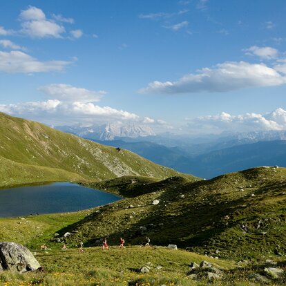 lago verde in estate con 4 escursionisti sul sentiero escursionistico | © Georg Tappeiner