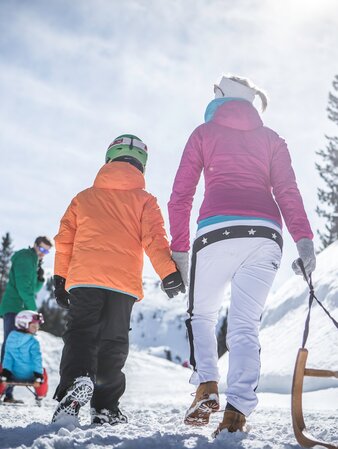 Family sledging in winter landscape | © Manuel Kottersteger