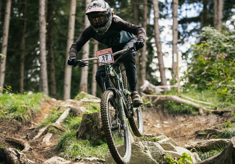 Ein Mountainbiker fährt über wurzeliges Geländer im Wald. | © Schwarzwälder