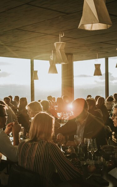 Das AlpiNN Restaurant voller Gäste bei Sonnenuntergang. | © Skirama Kronplatz