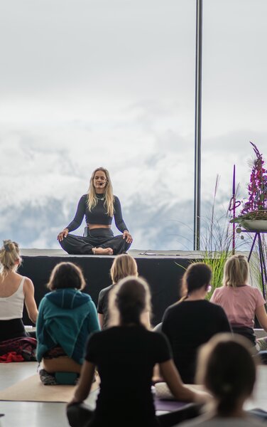 Eine Yogagruppe beim Unterricht mit der Berglandschaft im Hintergrund. | © Gianvito Coco