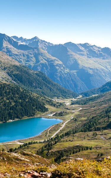 Ein Bergsee und im Hintergrund eine wunderschöne Berglandschaft im Sommer. | © Roter Rucksack