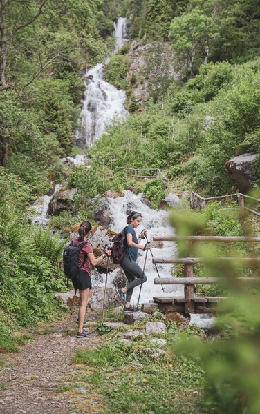 Zwei Frauen bewundern den Wasserfall vor ihnen. | © Anna Notdurfter