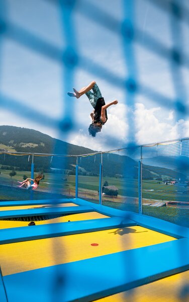 Ein Junge beim Trampolin-Springen im Sommer. | © Markus Ranalter