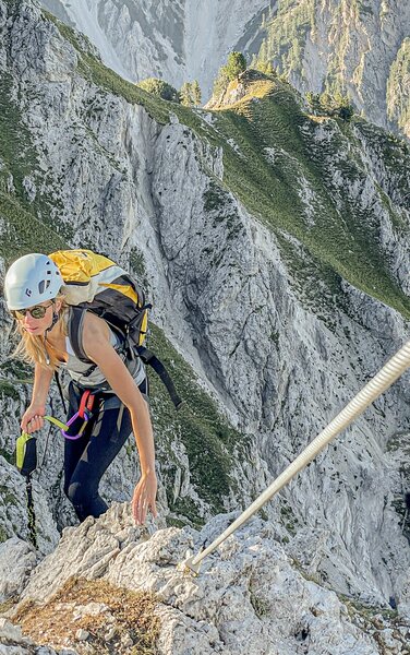Eine Bergsteigerin bei einem Klettersteig. | © Skirama Kronplatz