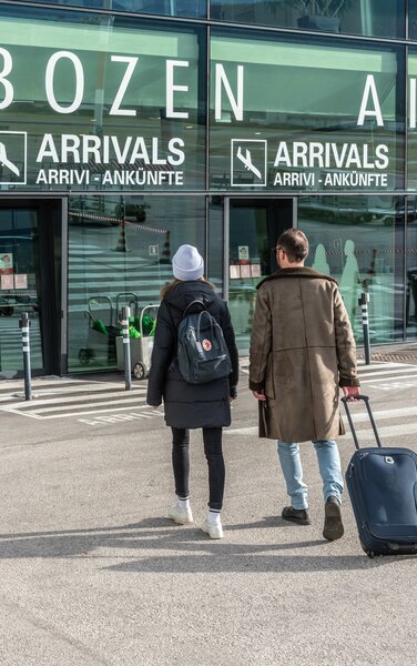 Ein Mann und eine Frau beim Ausgang des Flughafen Bozen. | © Skirama Kronplatz