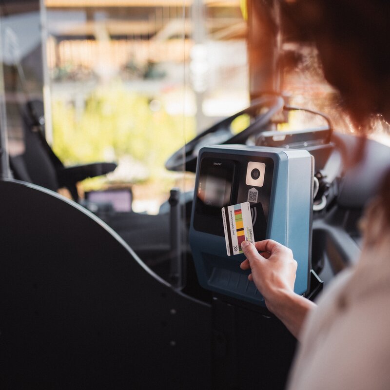 Eine Person entwertet ein Ticket an einem Fahrkartenautomaten in einem öffentlichen Verkehrsmittel. | © IDM Südtirol