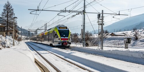 Zug im Winter fährt Richtung Bahnhof.