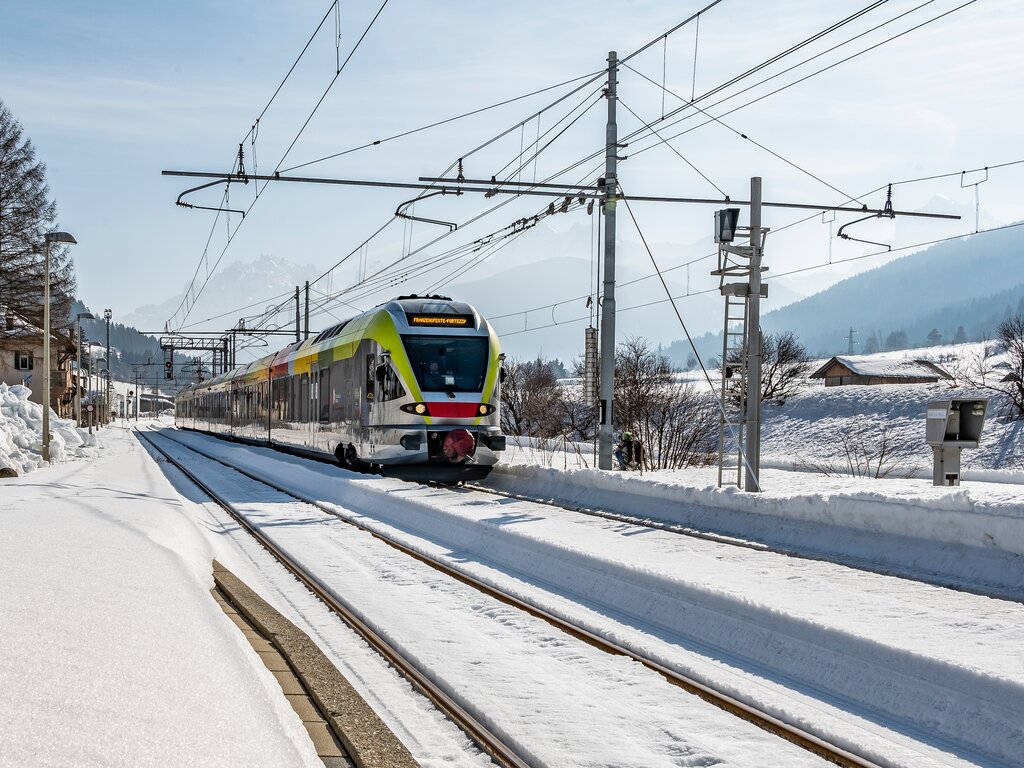 Zug im Winter fährt Richtung Bahnhof.