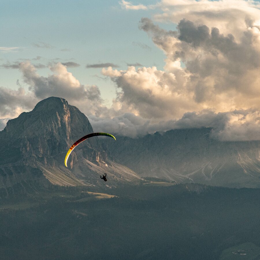 Ein Paragleiter vor dem Peitlerkofel bei Sonnenuntergang. | © Skirama Kronplatz
