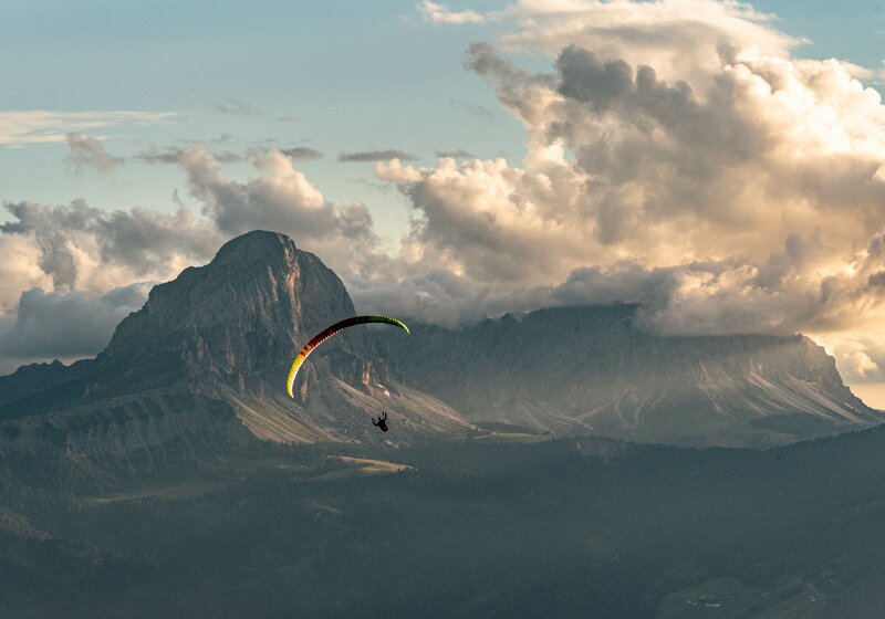 Ein Paragleiter vor dem Peitlerkofel bei Sonnenuntergang. | © Skirama Kronplatz