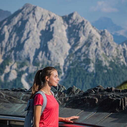 Eine Frau schaut von der Concordia Glocke auf die Dolomiten. | © Harald Wisthaler
