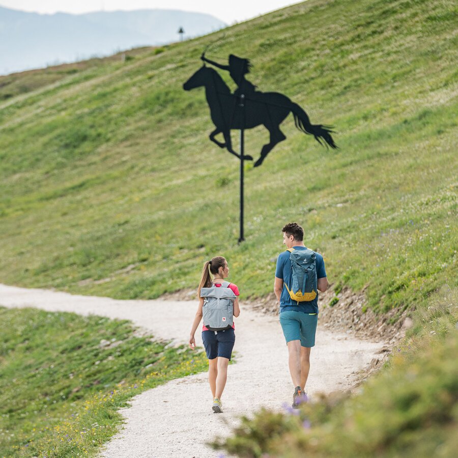 Ein Mann und eine Frau spazieren entlang des Panoramarundweges Concordia 360° zur Dolasilla-Statue. | © Harald Wisthaler