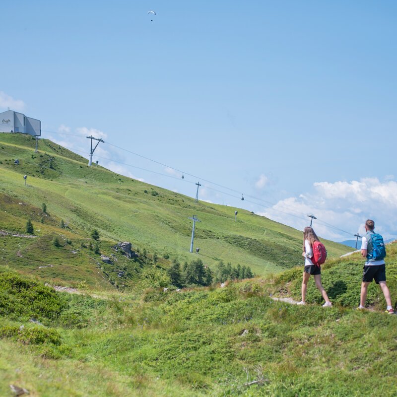 Ein Paar folgt einem Wanderweg in der Nähe der Kronplatz-Infrastruktur bei klarem Wetter. | © Gianvito Coco