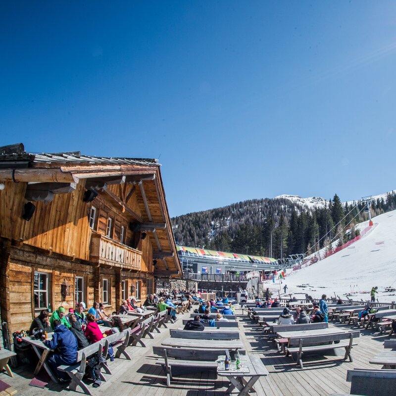 Die Terrasse der Herzlalm mit Blick auf die Piste bei wunderschönem Wetter. | © Harald Wisthaler
