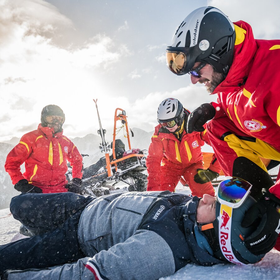 Die Mitarbeiter von der Pistenrettung helfen einer verletzten Person auf der Piste. | © Harald Wisthaler