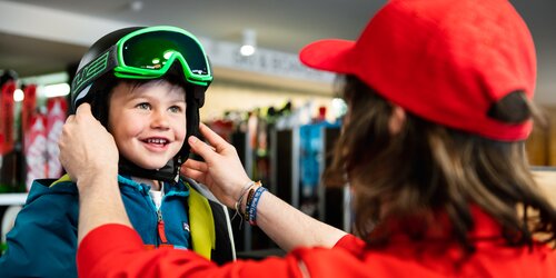 Ein Kind wird von einem Mitarbeiter des Skidepots beraten. | © Skiarea Miara