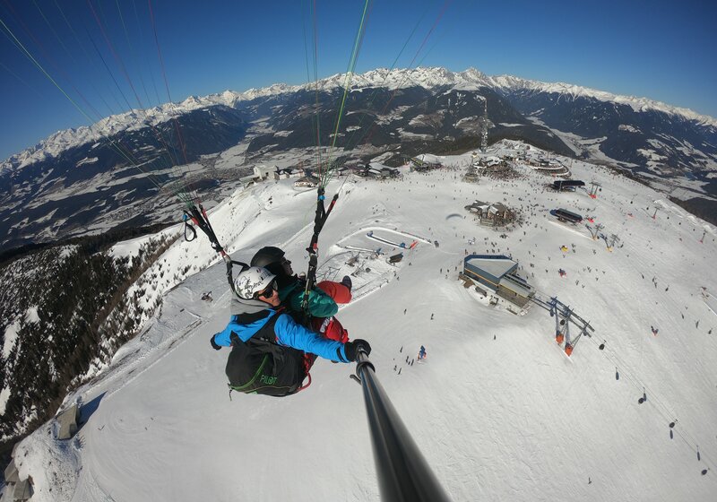 Paragleiter über dem Talkessel von Bruneck im Winter. | © Kronfly Tandem